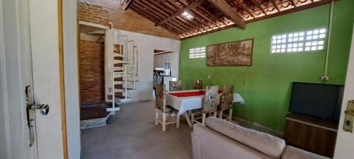 a living room with a green wall and a television at Meu refúgio in Japaratinga
