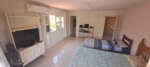 a bedroom with a bed and a flat screen tv at Meu refúgio in Japaratinga
