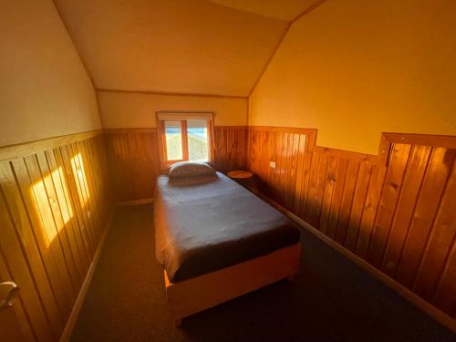 a small bedroom with a bed in a room at Oikos Arriendos in Futrono