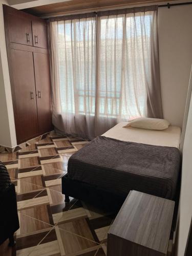 a small bedroom with two beds and a window at Aparta hotel Betania in Quimbaya