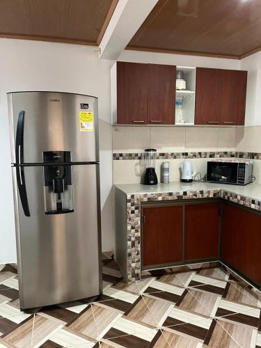 a kitchen with a stainless steel refrigerator at Aparta hotel Betania in Quimbaya