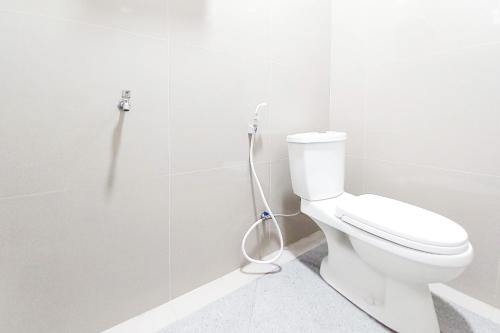 a bathroom with a toilet with a hose at RedDoorz Plus Syariah at Umyas Hotel near Terminal Anjuk Ladang Nganjuk in Nganjuk