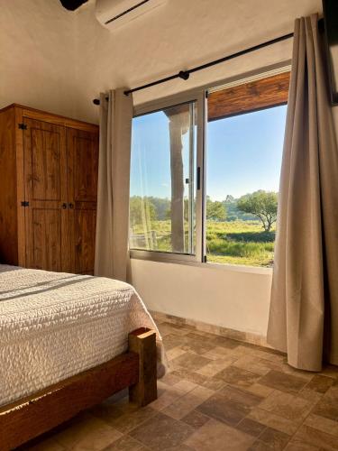 a bedroom with a bed and a large window at La Aruera in Salto