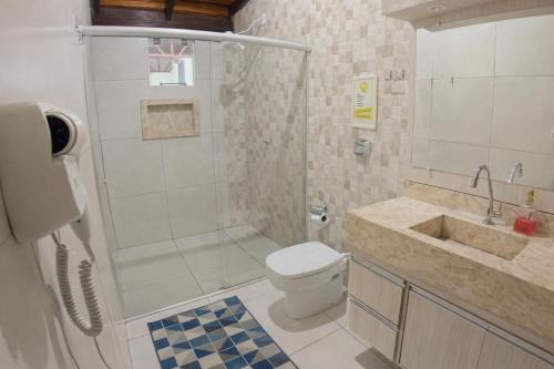 a bathroom with a shower and a toilet and a sink at Villa Kanindé Bonito in Bonito