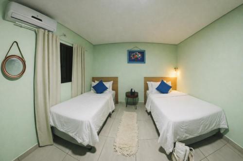 a bedroom with two beds and a window at Villa Kanindé Bonito in Bonito