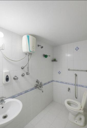 a white bathroom with a toilet and a sink at Luxurious Private Room in thane only for Male in Thane