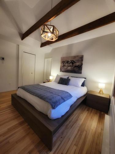 a large bedroom with a large bed and a chandelier at La Pergola-3 in Quebec City