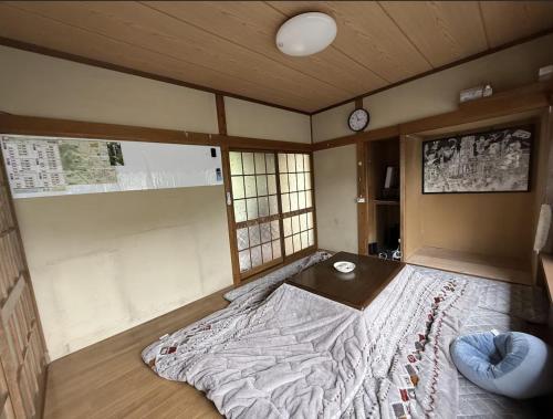 a bedroom with a bed with a table and a clock at 世界遺産平泉の一軒家ステイ 国際シェアハウス in Hiraizumi