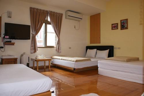 a hotel room with two beds and a television at Youran B&B in Jiufen