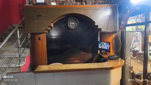 a room with a clock on a wall at Hotel Evergreen in Arāria