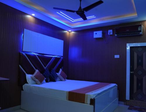 a bedroom with a bed with a ceiling fan at Hotel Evergreen in Arāria