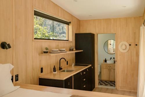 a kitchen with a sink and a window at Earth Tones Tiny Homes & Suites in Ollantaytambo