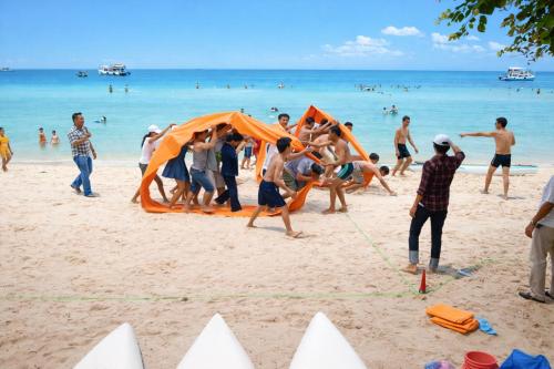 a group of people playing on a beach at Vườn Dừa Cam Bình 1 in Lagi