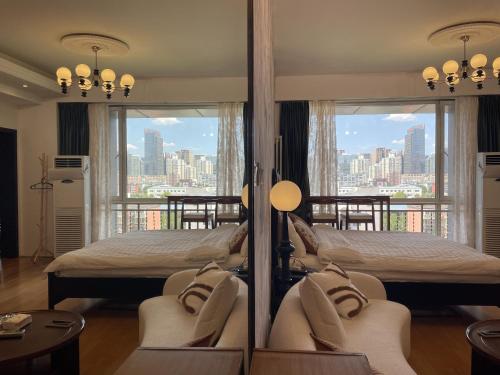 a hotel room with two beds and a balcony at Anju Apartment in Beijing