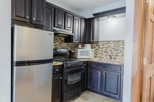a kitchen with black cabinets and a refrigerator at Jackson Town House Inn in Jackson