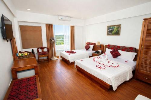 a hotel room with two beds and a television at Hoa Hồng Hotel 2 - Xã Đàn in Hanoi