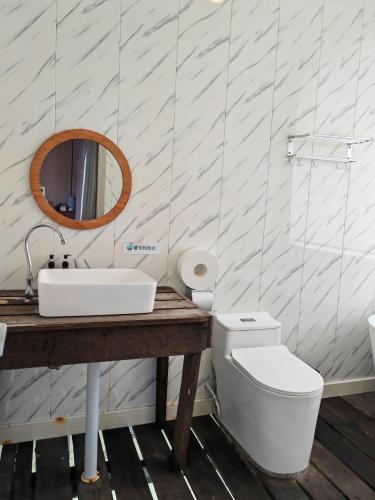 a bathroom with a sink and a toilet and a mirror at 微拉瓦丽 in Semporna