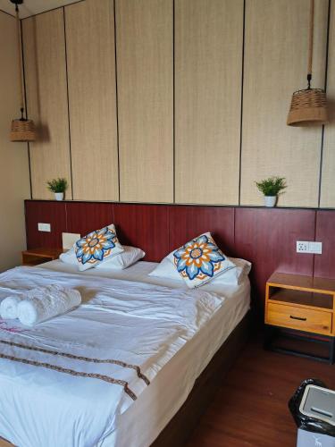 a bedroom with a bed with white sheets and pillows at 微拉瓦丽 in Semporna
