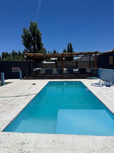 a blue swimming pool with a pergola at Luxfran in Uspallata