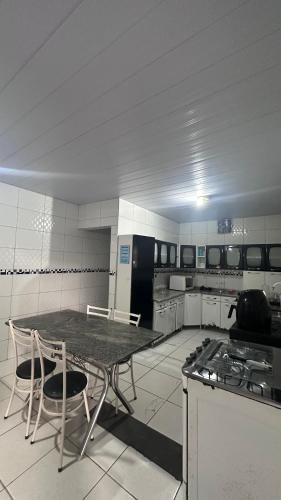 a large kitchen with a table and chairs in it at Casa espaçosa e arejada in Garanhuns