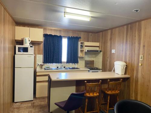 a small kitchen with a counter and a refrigerator at Miners Rest Units in Mount Magnet