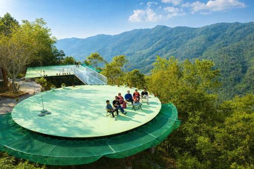 a group of people sitting on top of a green circularicultyiculty at Kolia Resort in Cao Bằng