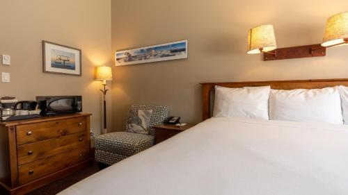 a bedroom with a bed and a tv and a chair at Cahilty #108 home in Sun Peaks