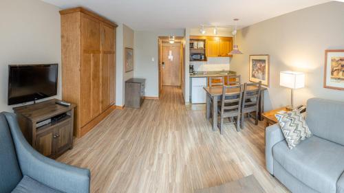 a living room with a couch and a tv and a kitchen at Cahilty #214 home in Sun Peaks