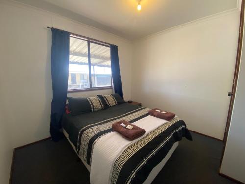 a bedroom with a bed with two towels on it at Miners Rest Units in Mount Magnet