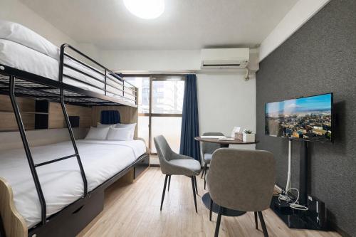 a bedroom with a bunk bed with a desk and a chair at サンシティ大濠公園 in Susakiuramachi