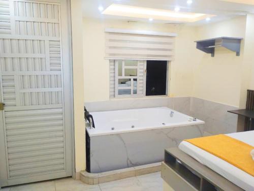 a white bath tub in a bathroom with a window at Hotel Magistral Suiter in Quibdó