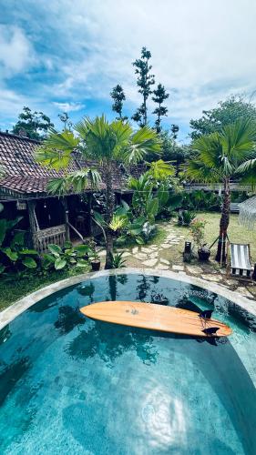 a surfboard is sitting in a swimming pool at Salty Siesta Stays in Selong Belanak