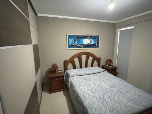 a small bedroom with a bed and two night stands at Dos D Point "pleno centro" in Río Tercero