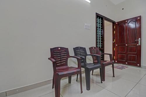 a row of chairs sitting next to a wall at Hotel O Skywind in Trivandrum