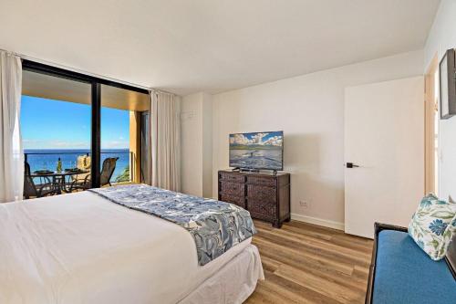 a bedroom with a bed and a view of the ocean at Mahana 718 in Lahaina