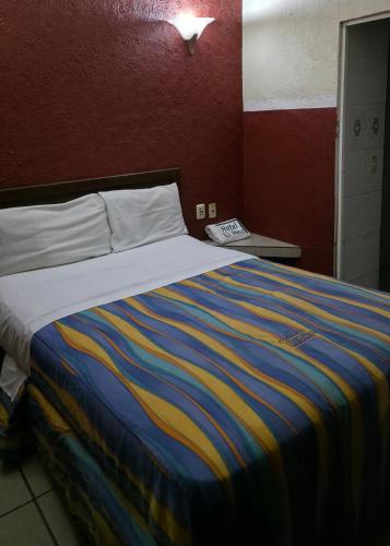 a bedroom with a bed with a colorful blanket at El Pino - Hotel Economico Guadalajara in Guadalajara