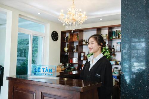 a woman standing at a bar in a salon at Orient Tam Đảo Hotel in Tam Ðảo