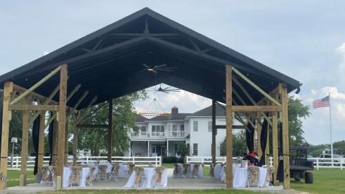 a pavilion with tables and chairs in front of a house at The Barn Apartment at Parkton Place in Hope Mills