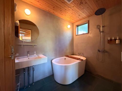 a bathroom with a large tub and two sinks at 月みるいえ in Akaoki