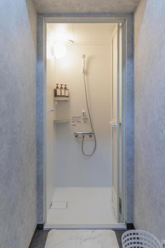 eine ebenerdige Dusche in einem Badezimmer mit Tür in der Unterkunft HOTEL STAY Plus in Imabari
