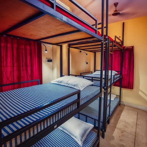 two bunk beds in a room with red curtains at ROAMERS INN Backpackers Hostel in Kolkata