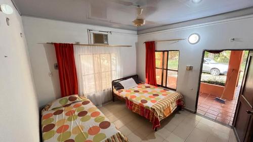 a bedroom with a bed and a window and a bed and a bedskirts at Eden Garden in Santa Marta