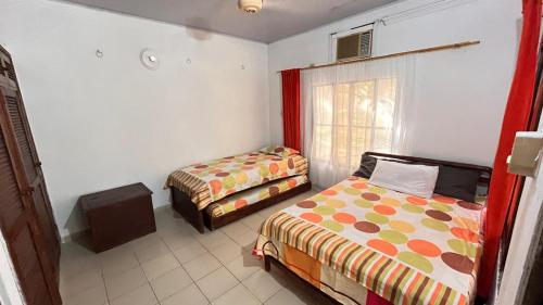a bedroom with two beds and a window at Eden Garden in Santa Marta