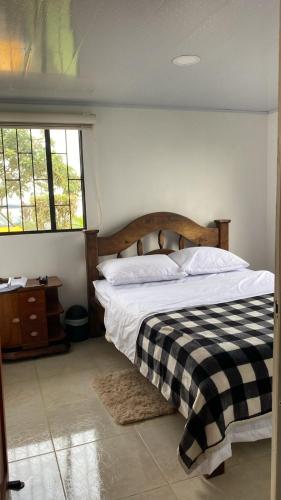 a bedroom with a bed with a black and white checkered blanket at Habitaciones cama doble in La Vega