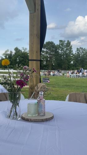 a white table with a cake and flowers on it at The Barn Apartment at Parkton Place in Hope Mills