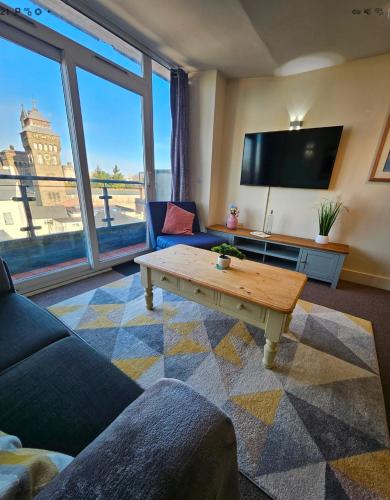 a living room with a table and a large window at Castle View Apartment, Cardiff City Centre in Cardiff