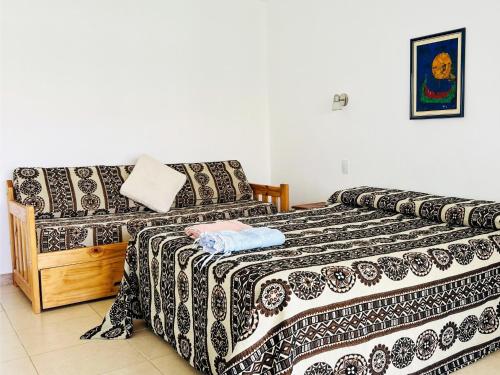 a bedroom with two beds and a couch at LA ESQUINA DE LA FLOR in Campo Quijano