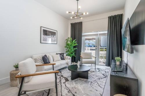 a living room with a couch and a table at Prime 2BR Location Near Miami FIFA World Cup Stadium - Private Parking - EV Station in Hallandale Beach