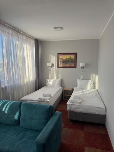 a living room with two beds and a couch at Carina Hotel in Tczew