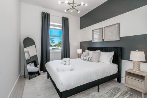 a bedroom with a large white bed and a window at Prime 2BR Location Near Miami FIFA World Cup Stadium - Private Parking - EV Station in Hallandale Beach